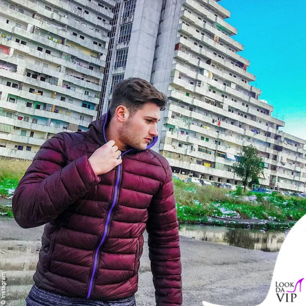 Christian Musella posa davanti alle Vele di Scampia con un piumino K-Way