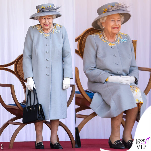 Elisabetta con un cappottino azzurro abbellito da fiori gialli ricamati e abbinato al cappello 