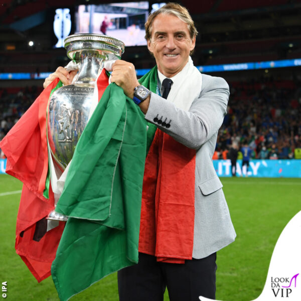 Roberto Mancini, con la divisa ufficiale Emporio Armani, stringe la coppa