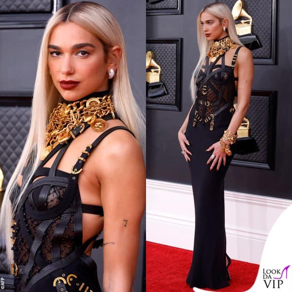 Il vestito nero con lacci e trasparenze è della collezione 1992 di Versace 