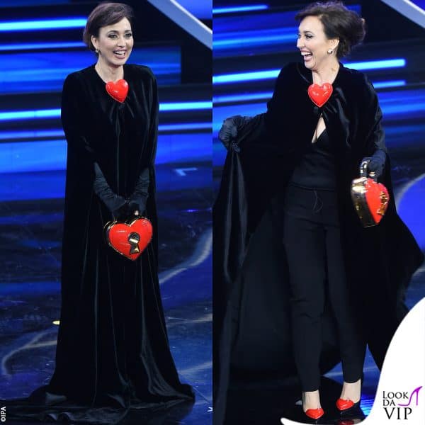 il primo look Moschino è caratterizzato da un mantello in velluto nero, con accessori a forma di cuore 