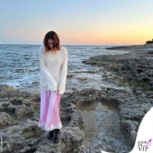 maglione beige e gonna rosa con dettaglio in pizzo per gli scatti sulle rocce 