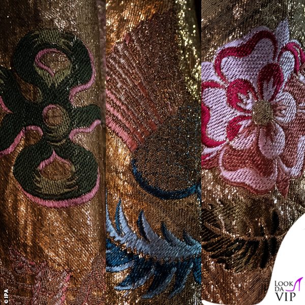 Sul mantello sono ricamati rose, cardi, quadrifogli, corone, aquile e gigli