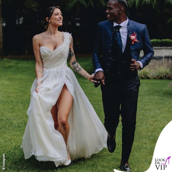 Giorgia Migliorati  e Enock Barwha in Carlo Pignatelli alle loro nozze: l'abito della sposa ha scollo asimmetrico e rouches