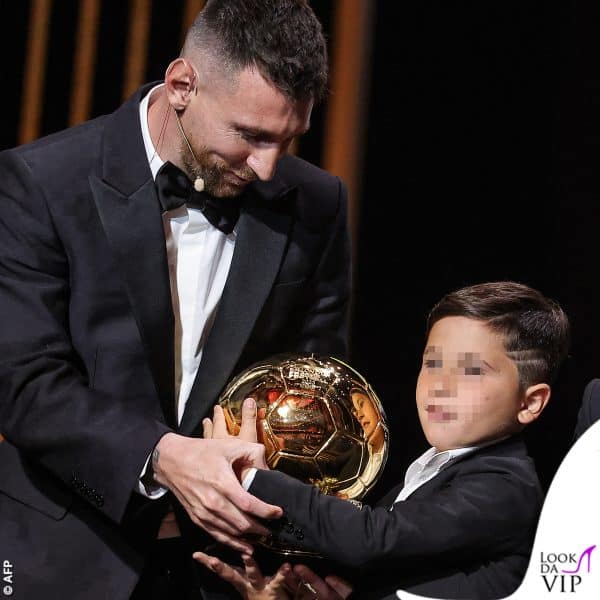 uno dei bimbi gli prende il Pallone d'Oro dalle mani 