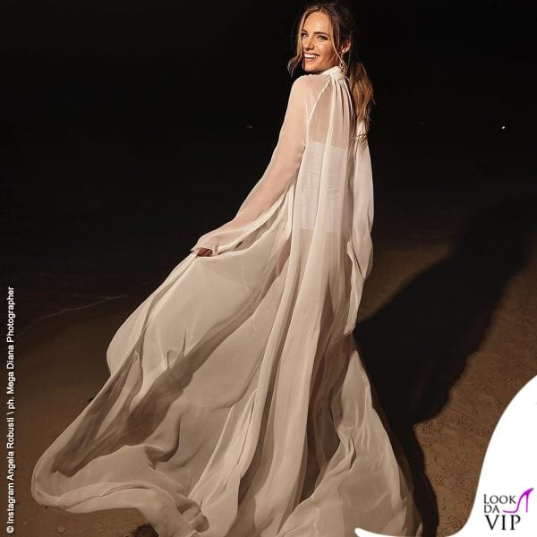 L'outfit è composto da una blusa oversize in seta naturale, con maniche lunghe e collo alto e body bianco