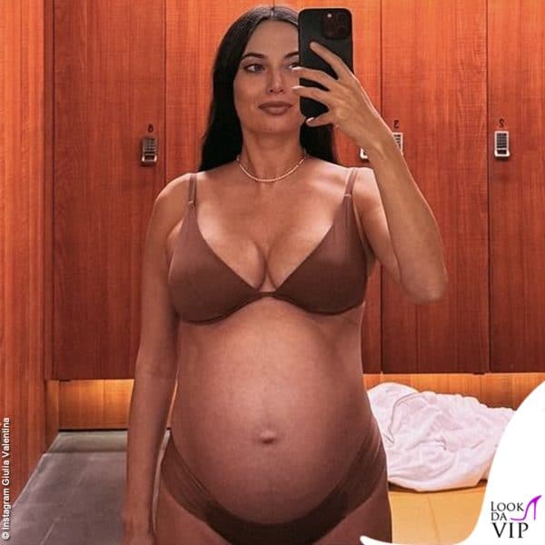 Allo specchio in lingerie sfoggia il pancione