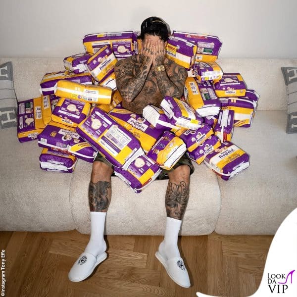 Tony sul divano, ironicamente sommerso di pacchi di pannolini 