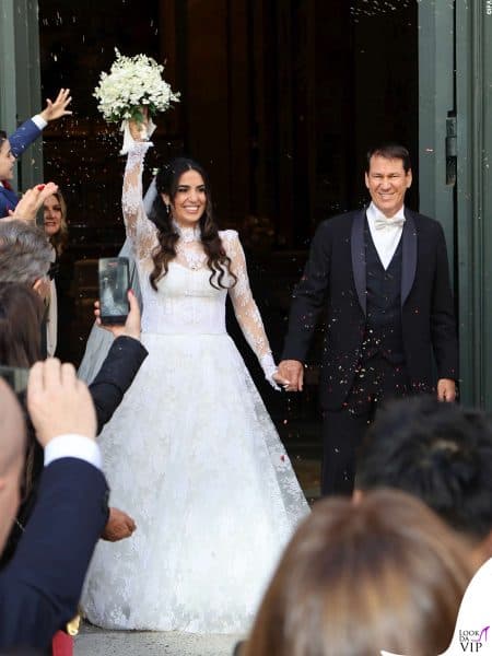 Francesca Brienza trionfante all'uscita dalla chiesa con il bouquet in alto.