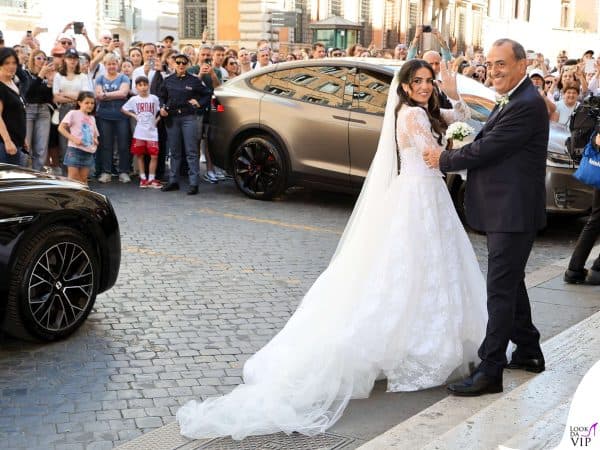 La sposa sorride e saluta tra gli applausi dei presenti.