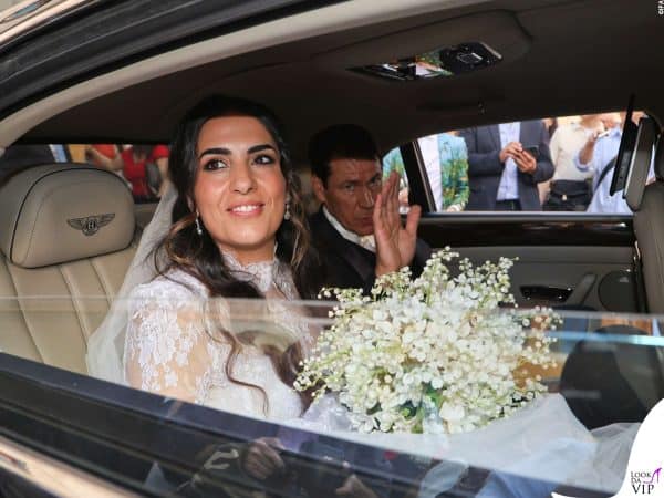 Francesca Brienza e Rudi Garcia sorridono e salutano dai sedili posteriori della Bentley.