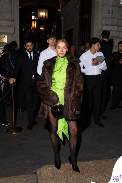 Caro Daur mostra le gambe con un body verde fluo e collant logati Gucci, completando l’outfit con una pelliccia vintage al Gucci after party di Milano.