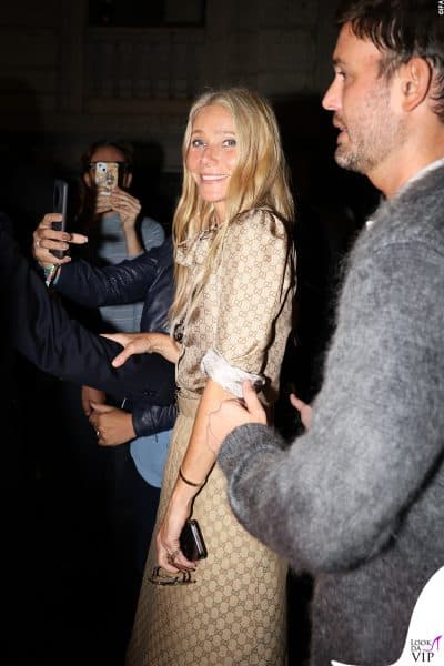 Gwyneth Paltrow saluta sorridente i fan all’ingresso del Gucci after party, elegantissima in un abito monogram GG beige con fiocco al collo, incarnando l’eleganza senza tempo del brand.