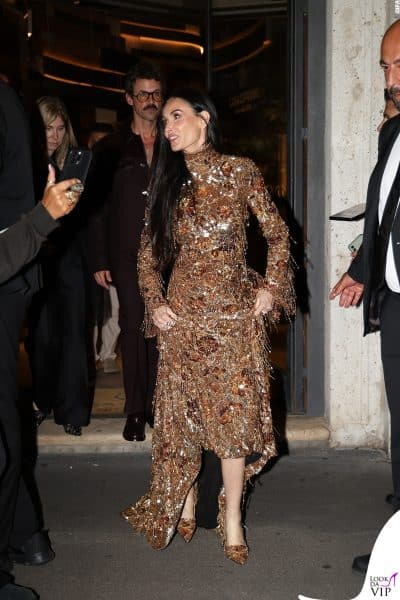 Uscita scenografica per Demi Moore al termine del Gucci party 2025. Il vestito oro scintillante con spacco e scarpe abbinate cattura l’attenzione di tutti.
