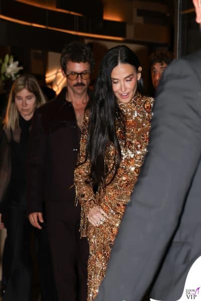 Demi Moore accolta da una folla di fan e fotografi al Gucci party. Il suo abito haute couture oro con dettagli ramati è uno dei più fotografati della serata.