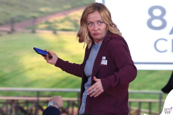 La premier Giorgia Meloni con una felpa sportiva bordeaux durante un incontro all’aperto: uno stile casual che sorprende.