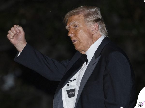 Gesto deciso e pugno alzato: Trump in smoking Made in Italy si mostra sicuro di sé.