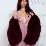 Jenna Ortega con pelliccia bordeaux in pelliccia sopra l’abito Amiri 