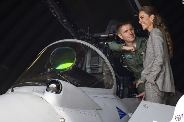 Sorridente e coinvolta, la Principessa ascolta un pilota nei pressi del jet da combattimento.